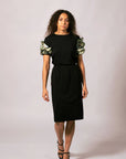 Front full-length view of model wearing the black Emma Gathered Sleeve Top featuring Kimberley Grass artwork ruffled sleeves, paired with a black skirt.