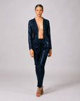 Front view of model wearing navy blue sequin pants paired with a matching blazer suit jacket.