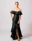 Model wearing the elegant black off-the-shoulder Martha Dress with a ruffled neckline and asymmetrical high-low hem.