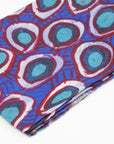 Close-up of folded Wildflowers 100% Cashmere Scarf displaying the detailed blue and red eyelet-style artwork inspired by the Yamatji landscape by Carol Martin.