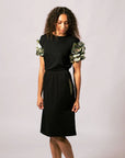 Model looking down wearing the black Emma Gathered Sleeve Top with Indigenous artwork sleeves by Lena Andrews.
