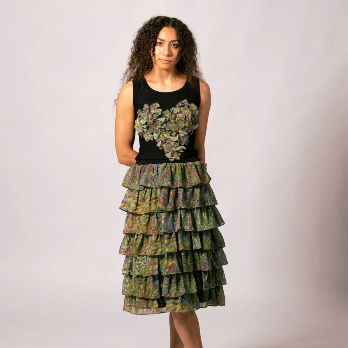 Front view of model wearing the black Lauren Heart Top featuring Lena Andrews artwork set with a tiered ruffle skirt.