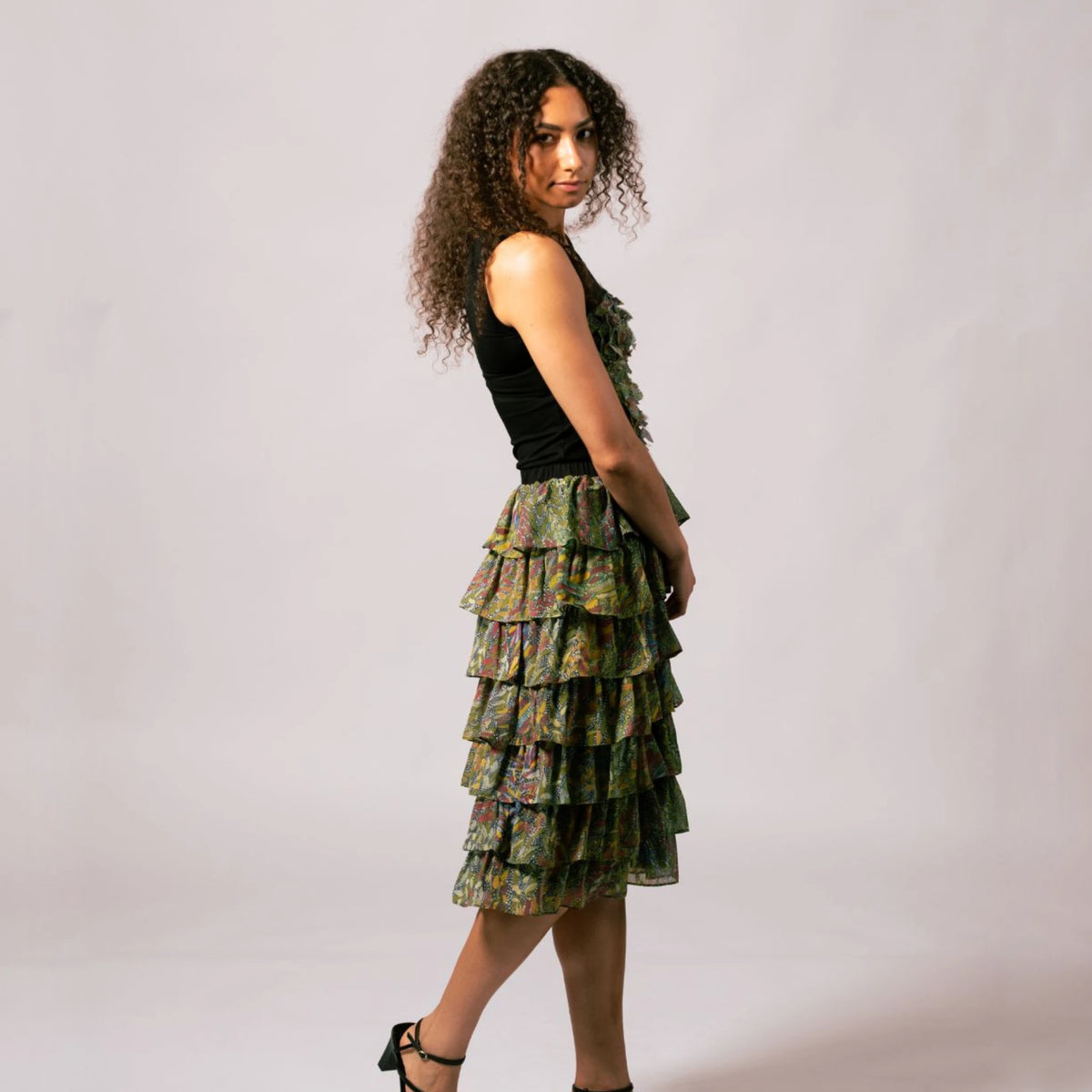 Side view of model wearing the black Lauren Heart Top paired with the matching tiered ruffle skirt in Kimberley Grass and Leaves print.