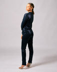 Side and back view of model wearing navy blue sequin pants with a matching sequin jacket.