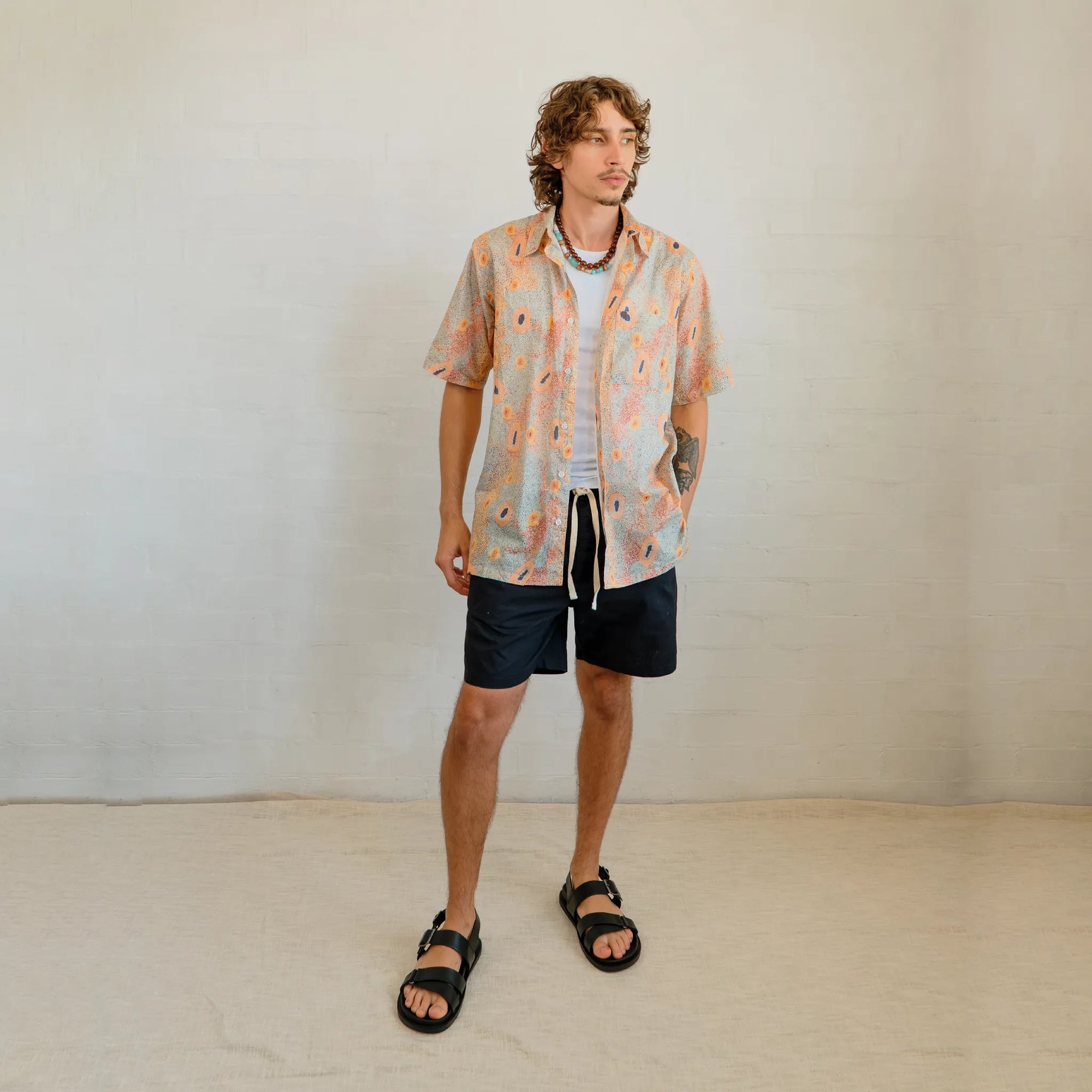 Kirrikin men's casual button-up short sleeve shirt with vibrant Australian Indigenous artwork by Sheryl Hicks.
