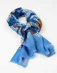 Kirrikin Split Jack Luxury Cashmere Scarf styled in a loose knot on a white background, featuring blue, orange, and white Indigenous dot artwork by Kaye White with frayed edges.