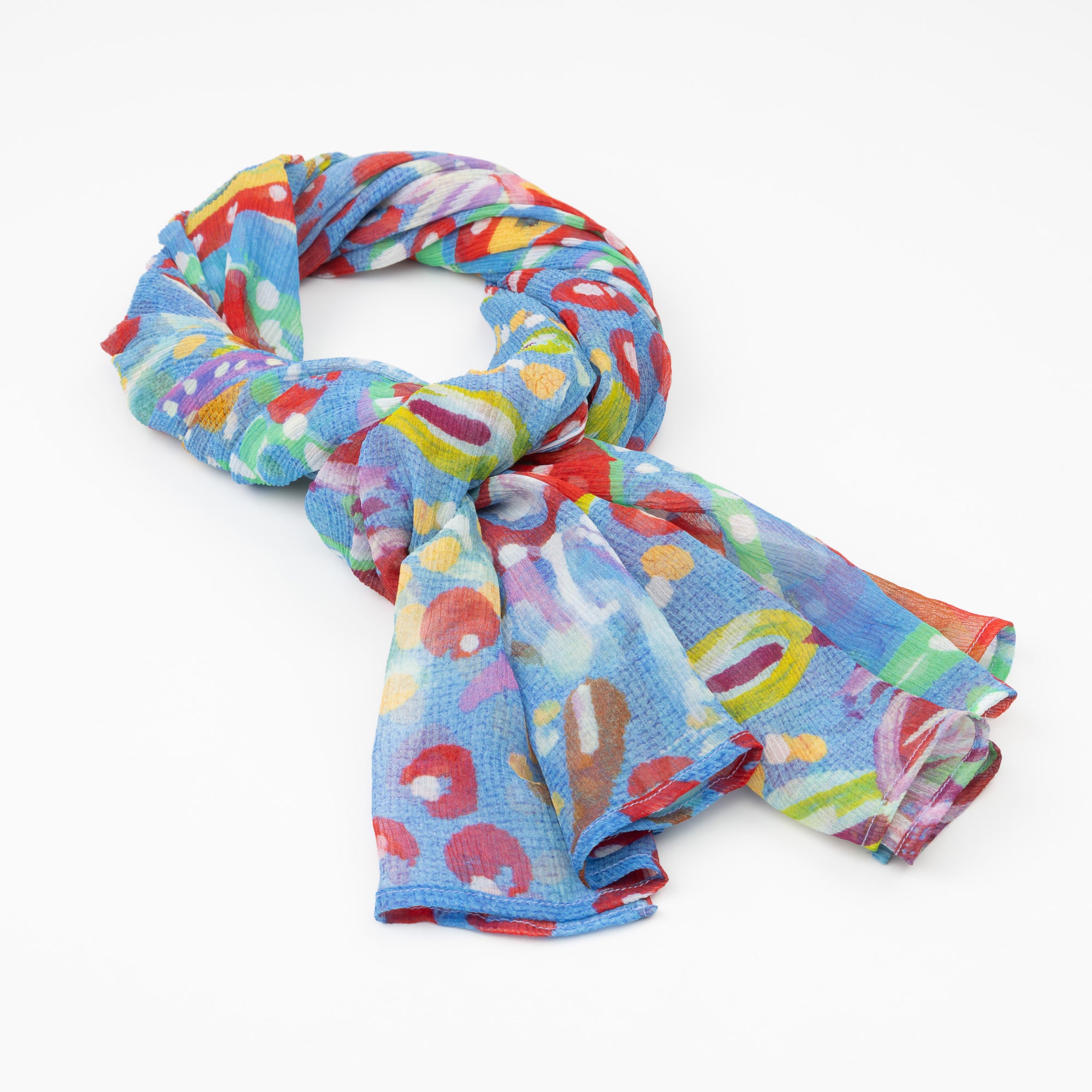 The luxury cashmere scarf with a vibrant Pilbara wildflower design by Sally White, draped in a loose knot.