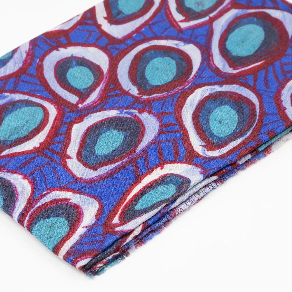 Close-up of folded Wildflowers 100% Cashmere Scarf displaying the detailed blue and red eyelet-style artwork inspired by the Yamatji landscape by Carol Martin.