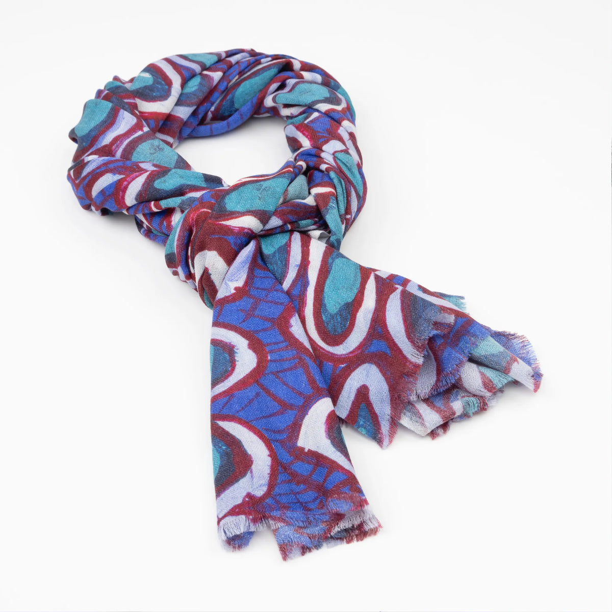 Kirrikin Wildflowers Luxury Cashmere Scarf styled in a loose knot, featuring bold blue, turquoise, red, and white circular Indigenous artwork by Carol Martin.