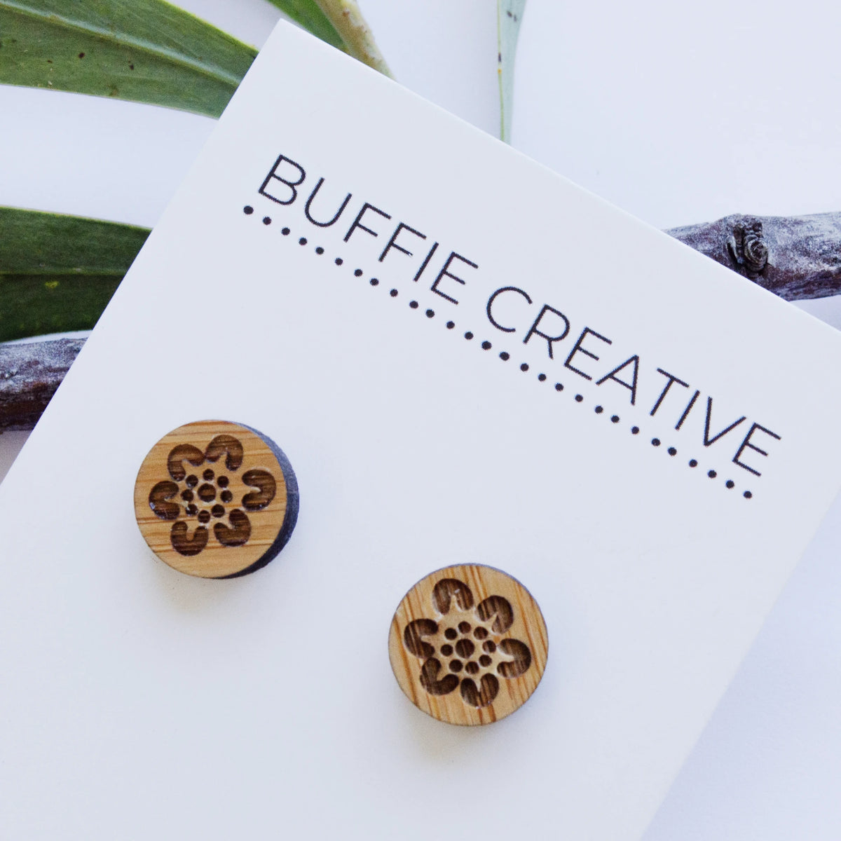 Round Wooden Floral Stud Earrings on Buffie Creative card packaging, featuring a natural timber finish with an engraved floral-inspired motif, designed by Buffie Punch.